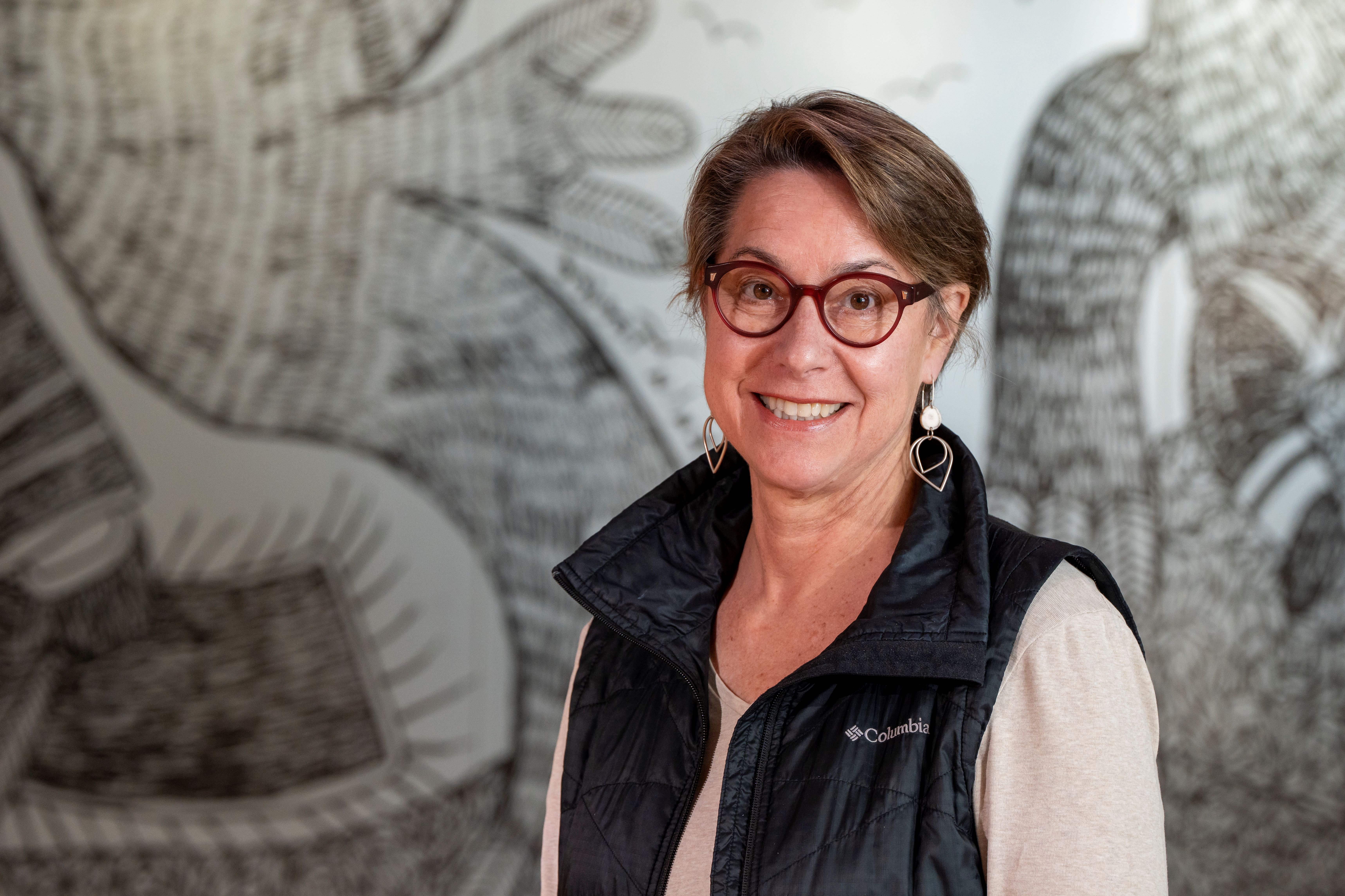 Janet King – Headshot photo of smiling woman with glasses.